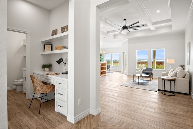 office featuring built in desk, ceiling fan with notable chandelier, light wood-type flooring, and coffered ceiling