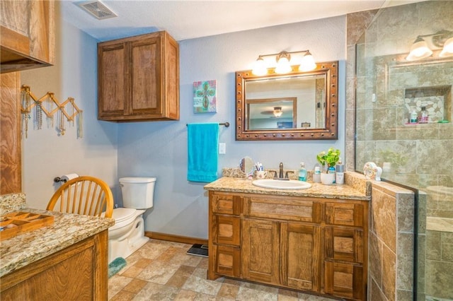 bathroom with vanity, toilet, and a shower with shower door