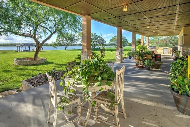 view of patio with exterior kitchen and a water view