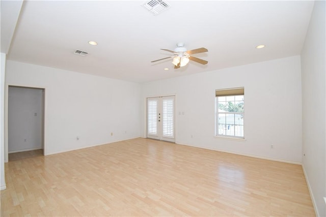 empty room featuring french doors, light hardwood / wood-style floors, and ceiling fan