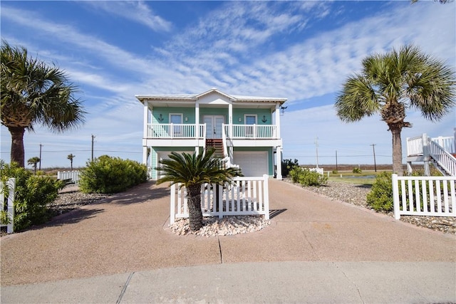 raised beach house with covered porch and a garage