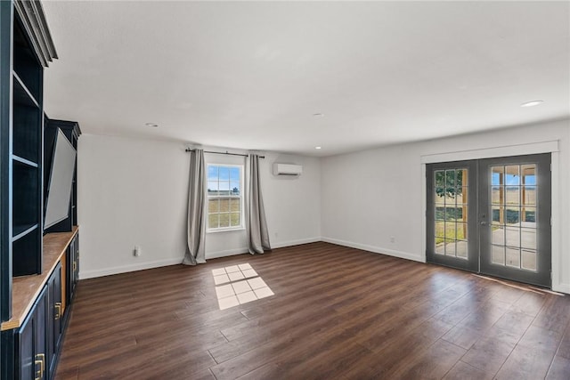 unfurnished room featuring french doors, dark hardwood / wood-style flooring, and a wall unit AC