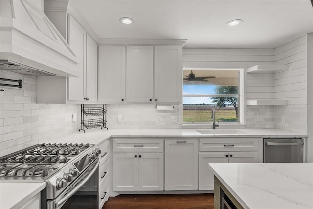 kitchen featuring appliances with stainless steel finishes, custom exhaust hood, white cabinets, and sink