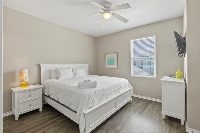 bedroom with dark hardwood / wood-style floors and ceiling fan