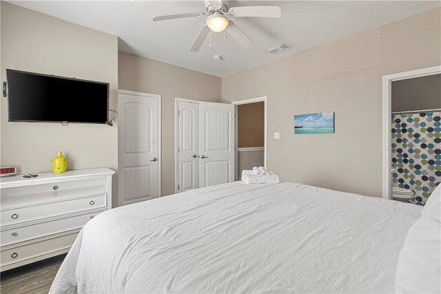 bedroom featuring dark wood-type flooring, ceiling fan, and multiple closets