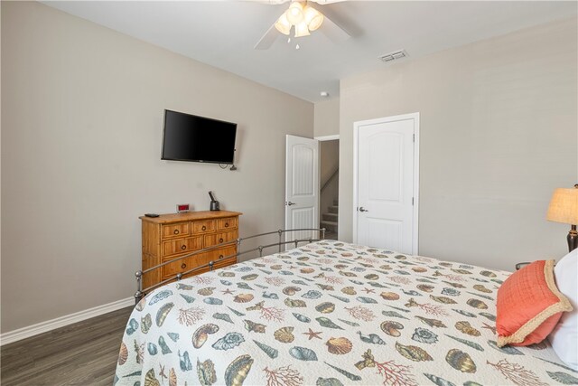 bedroom with dark hardwood / wood-style flooring and ceiling fan