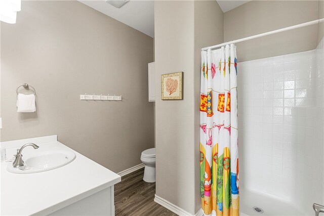 bathroom featuring hardwood / wood-style flooring, vanity, toilet, and walk in shower