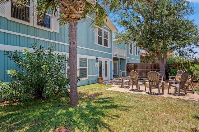 rear view of house featuring a patio and a lawn