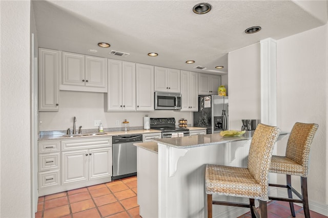 kitchen with sink, a breakfast bar area, stainless steel appliances, and kitchen peninsula