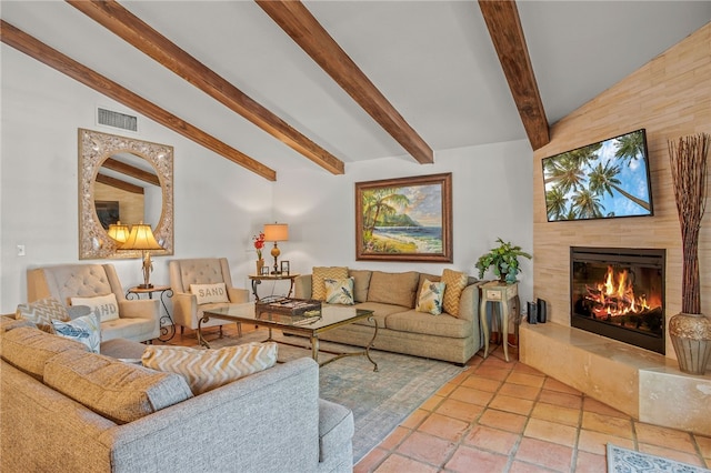 living room featuring lofted ceiling with beams and a tile fireplace