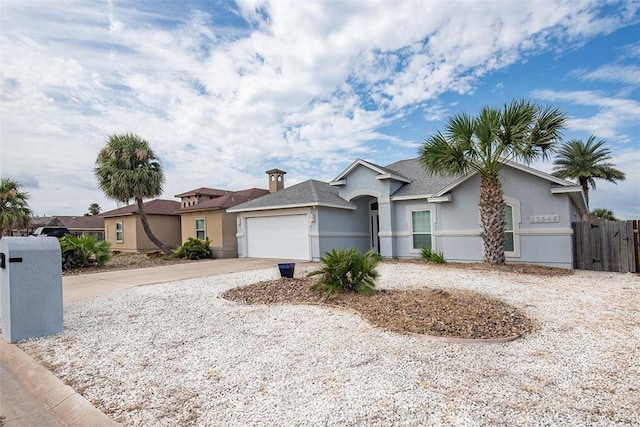 single story home featuring an attached garage, stucco siding, driveway, and fence