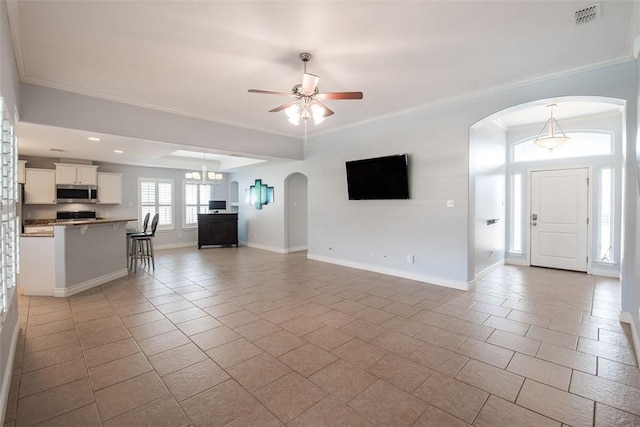 unfurnished living room featuring ceiling fan with notable chandelier, visible vents, arched walkways, light tile patterned floors, and baseboards