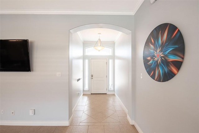 foyer with crown molding, baseboards, arched walkways, and light tile patterned floors