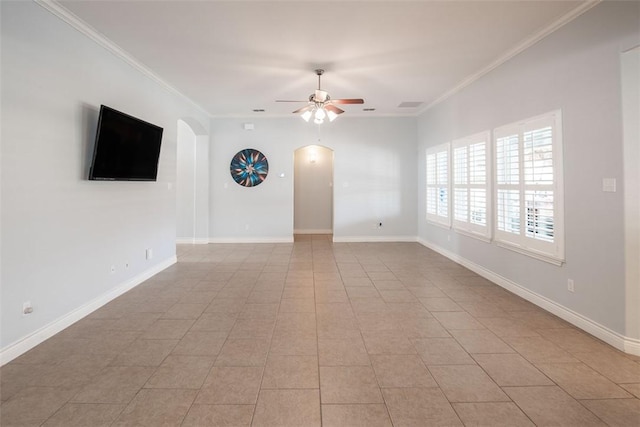 unfurnished living room with ornamental molding, arched walkways, a ceiling fan, and baseboards