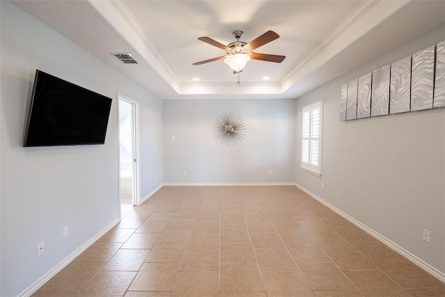 unfurnished room with light tile patterned floors, a tray ceiling, visible vents, baseboards, and ceiling fan