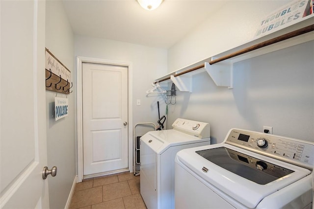clothes washing area with laundry area, light tile patterned flooring, baseboards, and independent washer and dryer