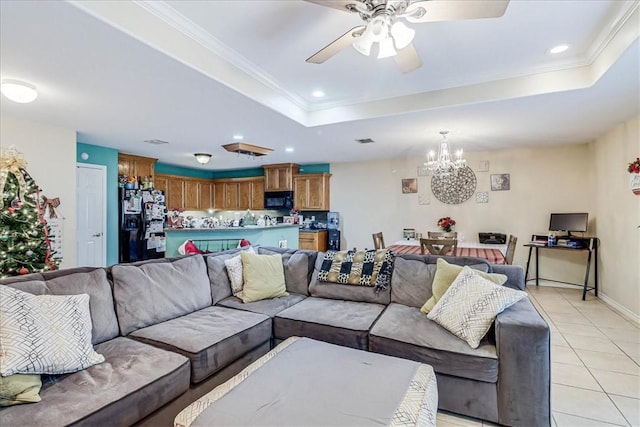 living room featuring light tile patterned floors, ceiling fan with notable chandelier, a tray ceiling, and crown molding