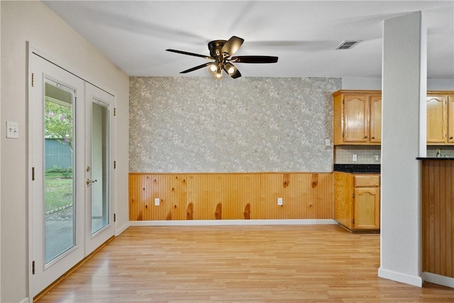 3606 Emory Dr, Corpus Christi, TX 78410 - unfurnished dining area with light wood-style floors, a ceiling fan, wainscoting, and wooden walls