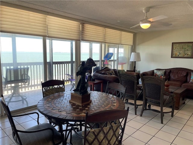 4242 Gulfbreeze Blvd Unit 606, Corpus Christi, TX 78402 - dining space featuring light tile patterned floors, a textured ceiling, a ceiling fan, healthy amount of natural light, and a water view
