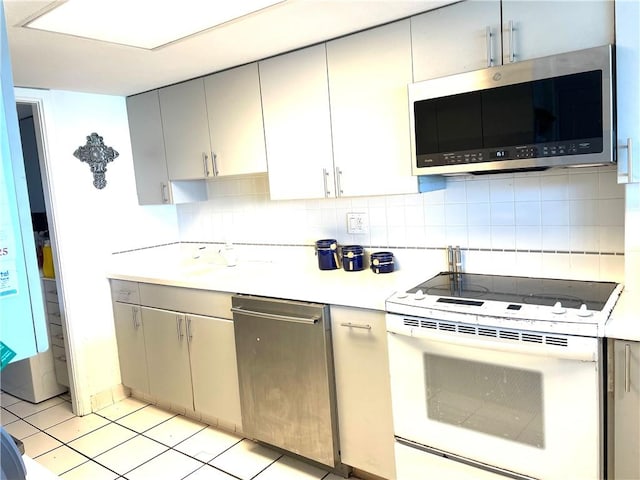 4242 Gulfbreeze Blvd Unit 606, Corpus Christi, TX 78402 - kitchen with stainless steel appliances, light countertops, gray cabinetry, and backsplash