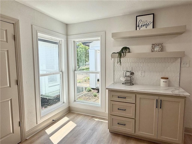 2413 Still Brook Dr, Corpus Christi, TX 78414 - bar with light wood-type flooring, baseboards, and backsplash