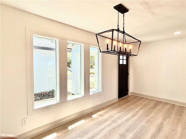 2413 Still Brook Dr, Corpus Christi, TX 78414 - unfurnished dining area featuring a chandelier, light wood finished floors, and baseboards