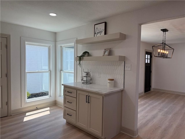 2413 Still Brook Dr, Corpus Christi, TX 78414 - kitchen featuring hanging light fixtures, baseboards, open shelves, an inviting chandelier, and light wood-style floors