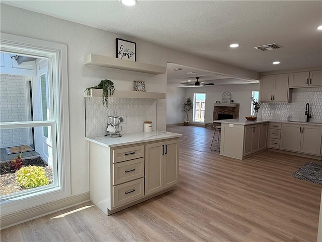 2413 Still Brook Dr, Corpus Christi, TX 78414 - kitchen featuring a sink, visible vents, light wood-type flooring, and a fireplace