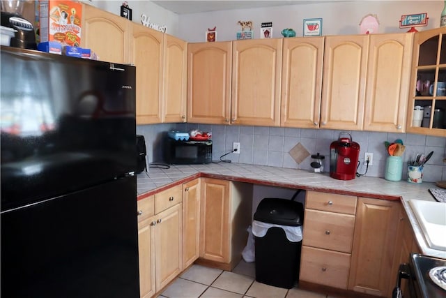 4625 Mildred Dr, Corpus Christi, TX 78411 - kitchen featuring tile counters, light brown cabinetry, black appliances, and glass insert cabinets