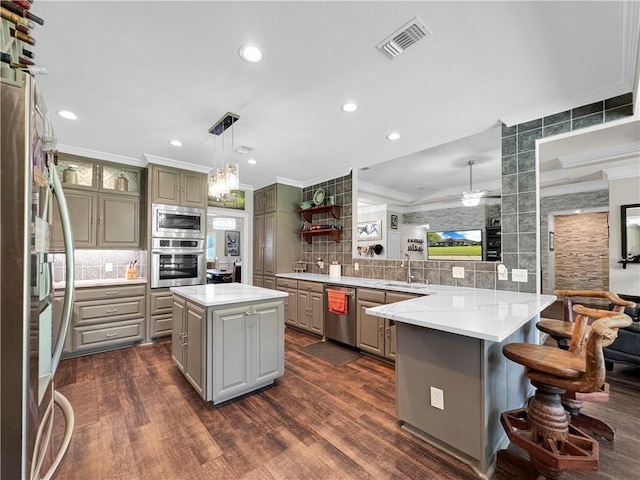 13910 Riverway Dr, Corpus Christi, TX 78410 - kitchen with stainless steel appliances, gray cabinets, crown molding, a peninsula, and tasteful backsplash