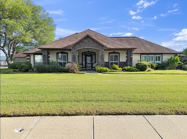 13910 Riverway Dr, Corpus Christi, TX 78410 - view of front of home with stucco siding, stone siding, and a front yard