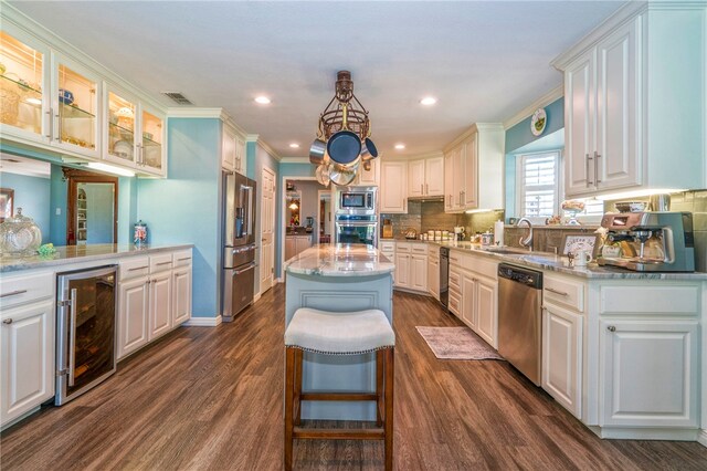 kitchen with wine cooler, a kitchen island, dark wood-type flooring, and appliances with stainless steel finishes