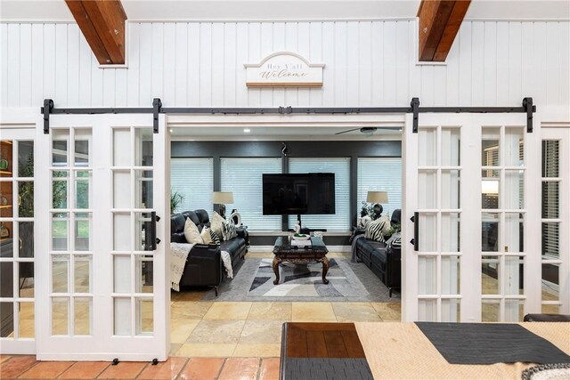 11157 Jackson Ter, Corpus Christi, TX 78410 - living room featuring a barn door, beam ceiling, and stone tile flooring