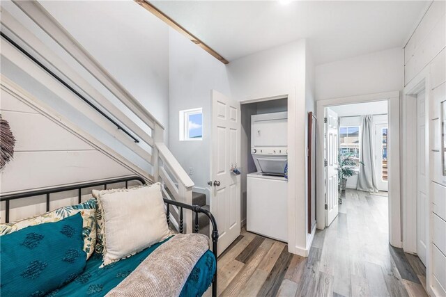 1002 State Highway 361, Port Aransas, TX 78373 - laundry area with stacked washer / dryer, wood finished floors, and plenty of natural light