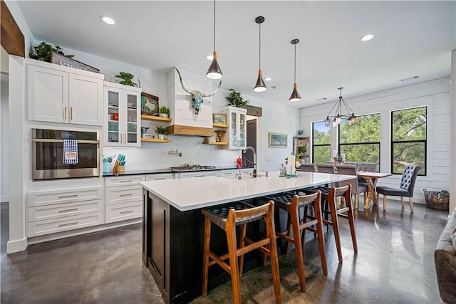 340 Warbler Dr, Spring Branch, TX 78070 - kitchen with appliances with stainless steel finishes, a sink, tasteful backsplash, finished concrete floors, and glass insert cabinets