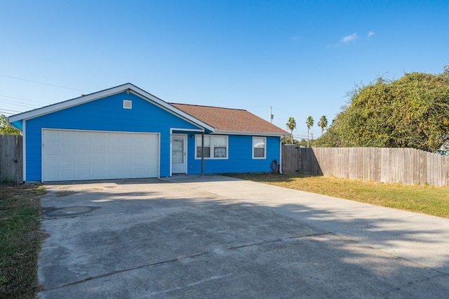 ranch-style house featuring concrete driveway, an attached garage, and fence