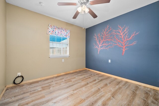 spare room with ceiling fan, baseboards, and wood finished floors