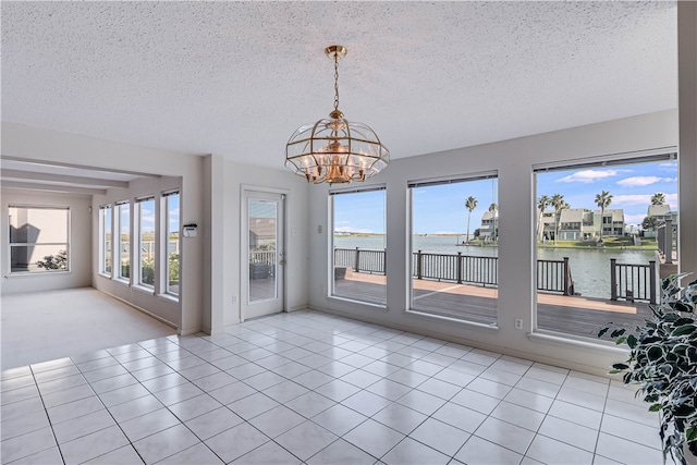 interior space featuring a water view, a textured ceiling, and a notable chandelier