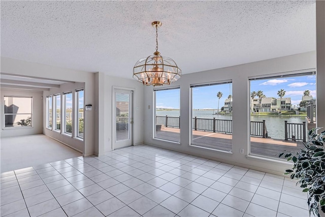 13714 A La Entrada St, Corpus Christi, TX 78418 - unfurnished dining area with a chandelier, a textured ceiling, a water view, and tile patterned flooring