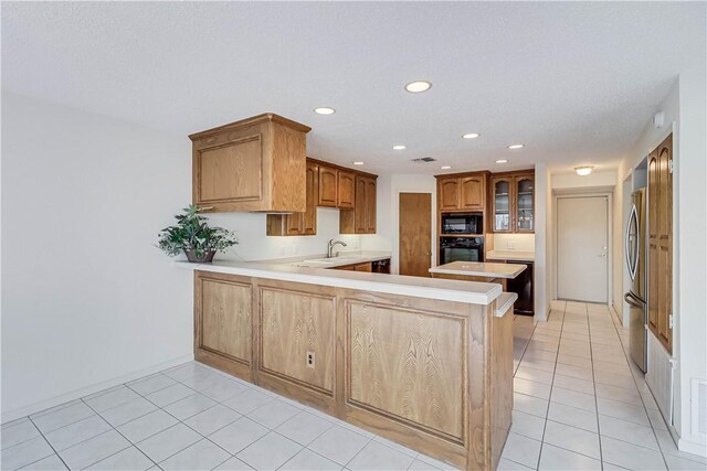 13714 A La Entrada St, Corpus Christi, TX 78418 - kitchen featuring black appliances, a peninsula, light countertops, recessed lighting, and light tile patterned floors