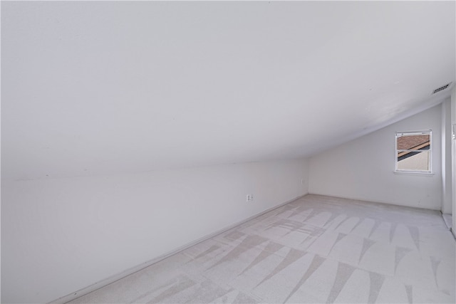 additional living space with light carpet and lofted ceiling