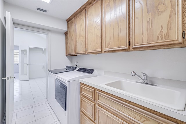 clothes washing area with cabinets, sink, independent washer and dryer, and light tile patterned floors