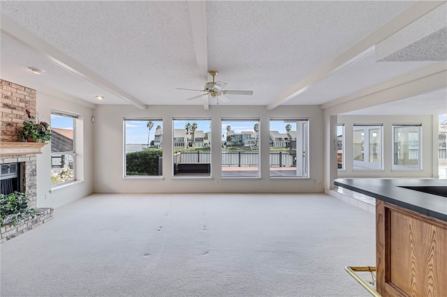 unfurnished living room featuring a textured ceiling, light carpet, and beam ceiling