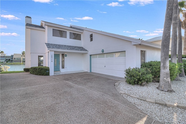 view of front of property featuring a garage and a water view