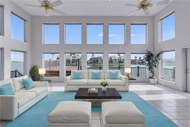 sunroom / solarium featuring ceiling fan and a water view