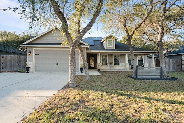 view of front of property with a garage, a front lawn, solar panels, and a porch