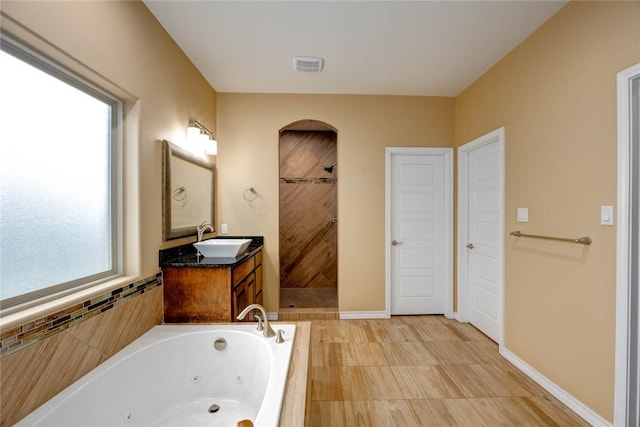 bathroom featuring a whirlpool tub, tiled shower, visible vents, and a healthy amount of sunlight