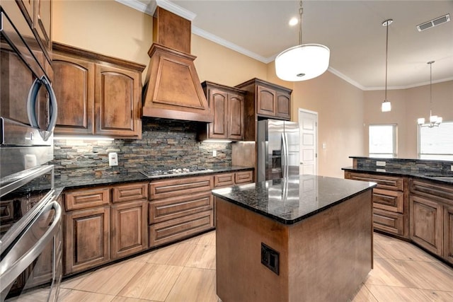 kitchen with visible vents, decorative backsplash, appliances with stainless steel finishes, dark stone countertops, and a center island