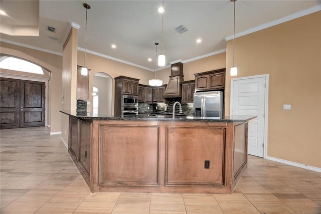 kitchen featuring visible vents, arched walkways, backsplash, stainless steel appliances, and a sink