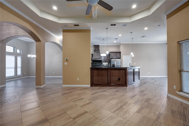 kitchen with premium range hood, visible vents, open floor plan, stainless steel refrigerator with ice dispenser, and a raised ceiling